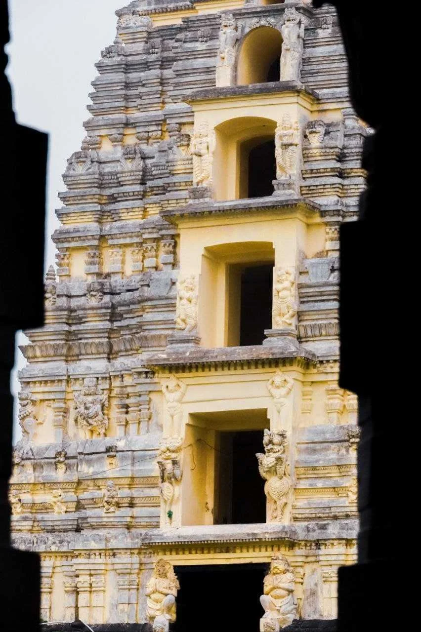 A sunlit, carved temple tower against a dark backdrop