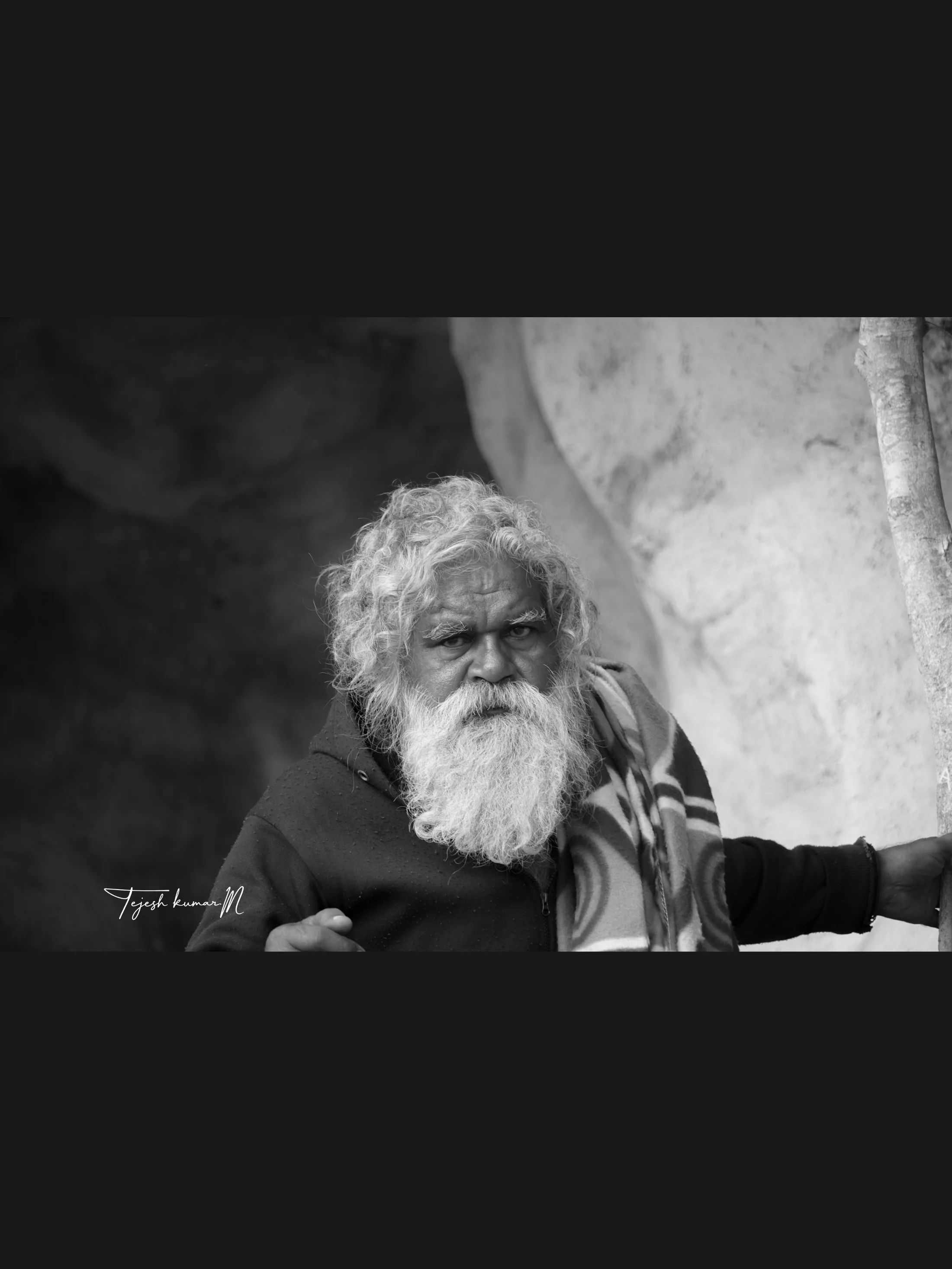 Black-and-white portrait of an elderly bearded person